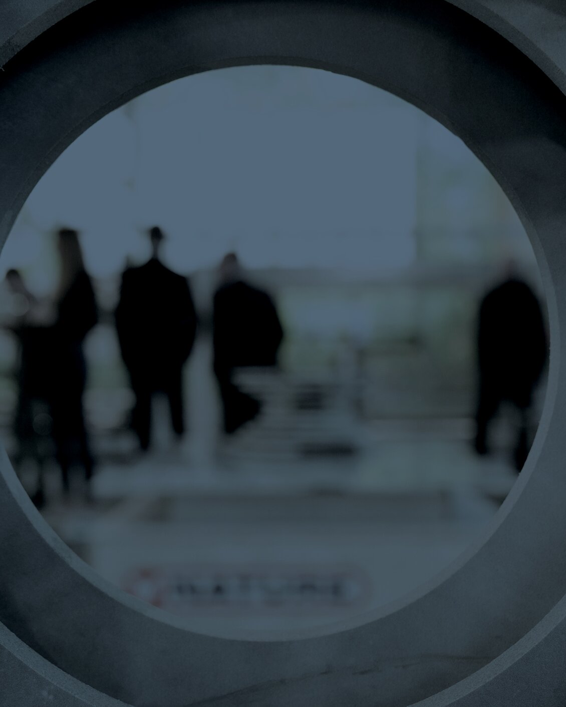 Persone a TECNA viste attraverso grandi strutture circolari concentriche, creando un effetto visivo astratto e architettonico.