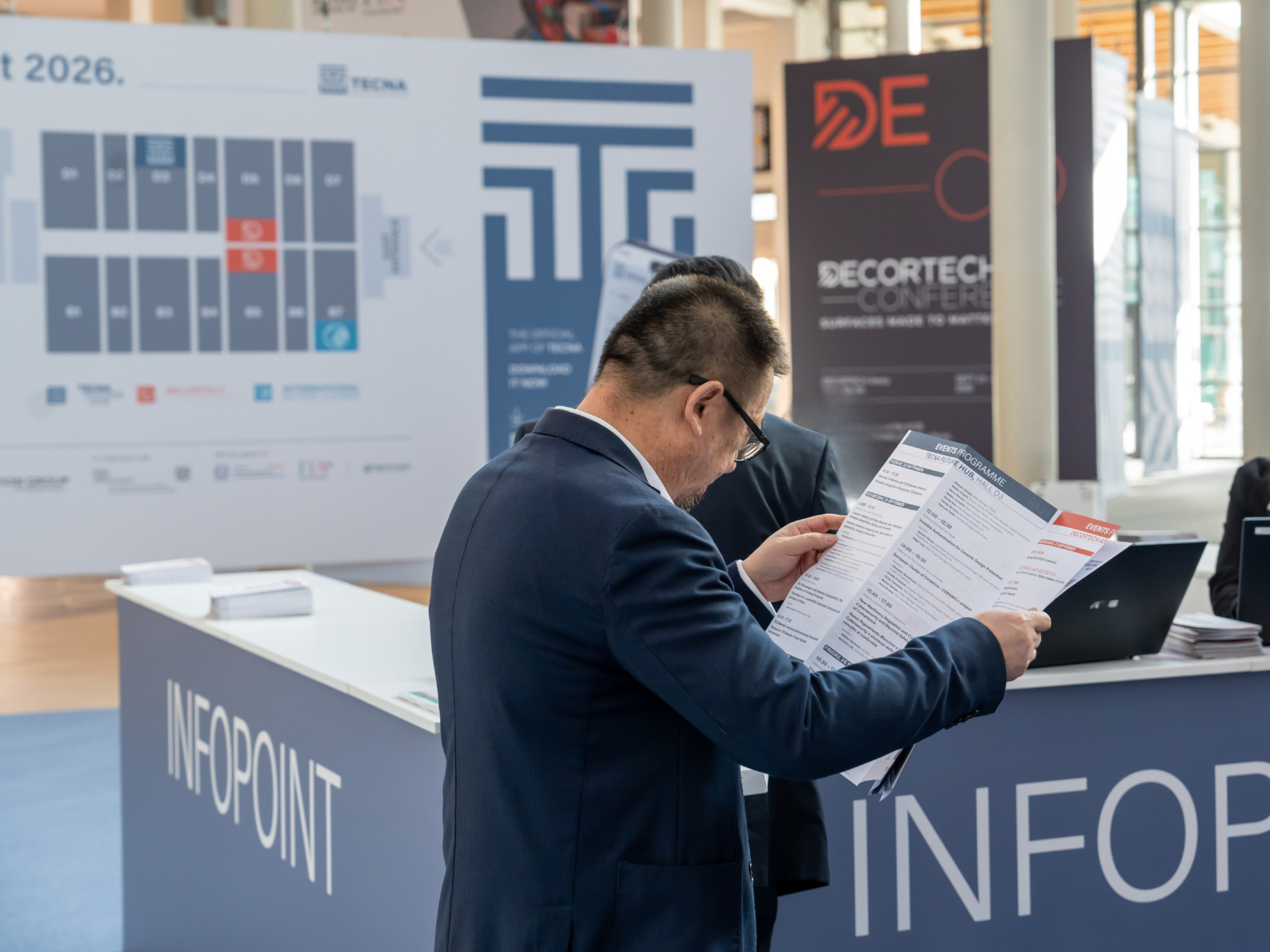 Visitatore che consulta la mappa della fiera davanti all'Info Point