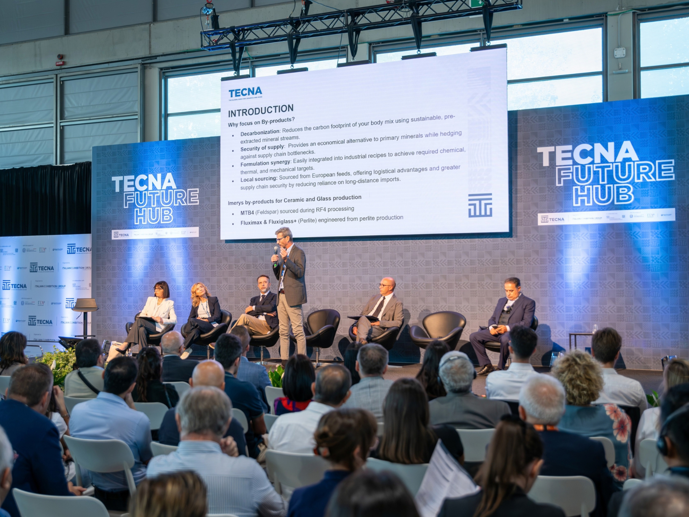 Sessione convegnistica al TECNA Future Hub 2026 con relatori sul palco e pubblico in sala, dedicata ai principali temi della filiera ceramica: materie prime, intralogistica, innovazione sostenibile, digitalizzazione, Industria 4.0 e competitività internazionale.