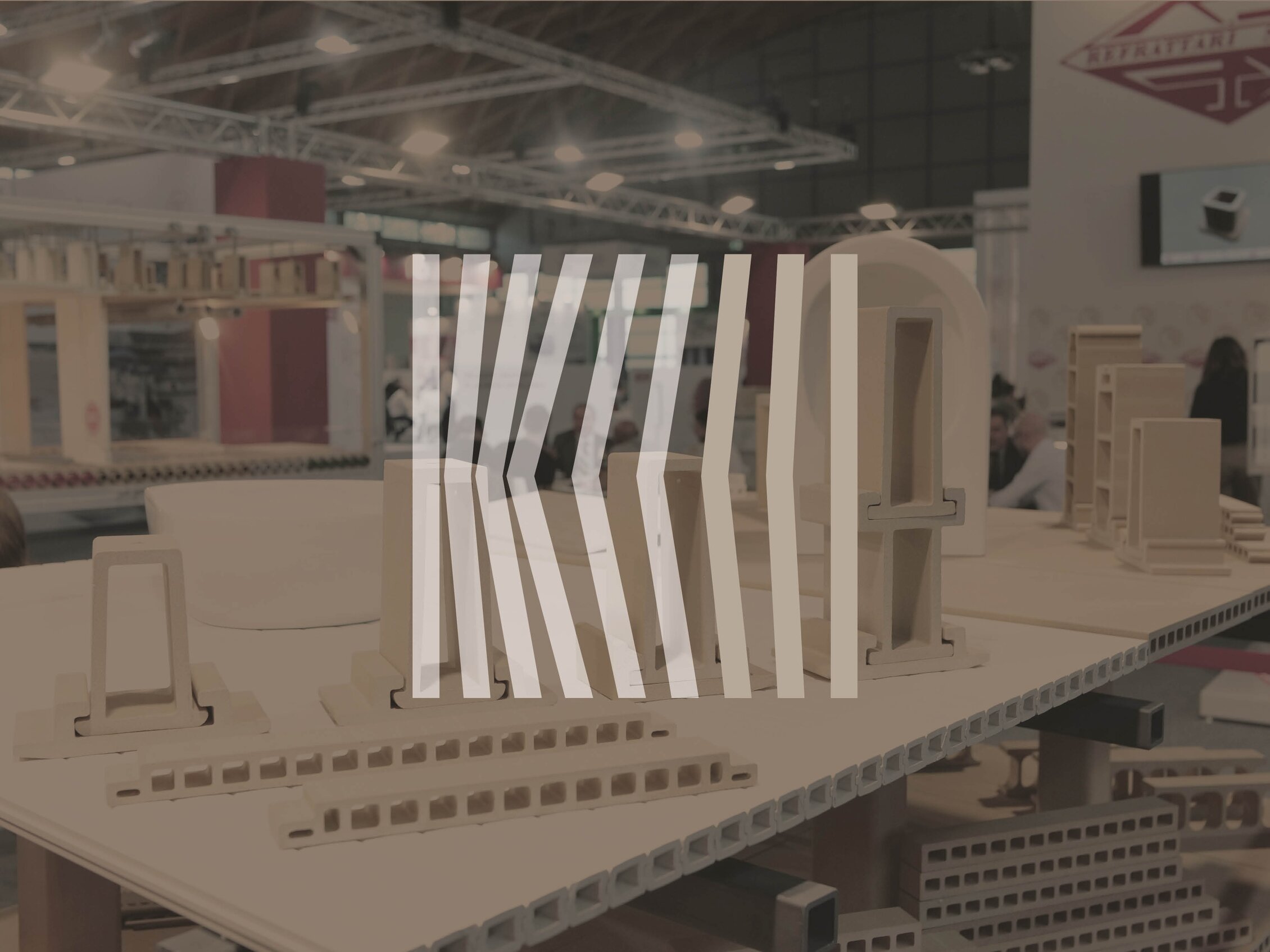 Componenti e modelli in laterizio esposti su un banco tecnico, rappresentativi delle tecnologie per la produzione di mattoni e tegole.