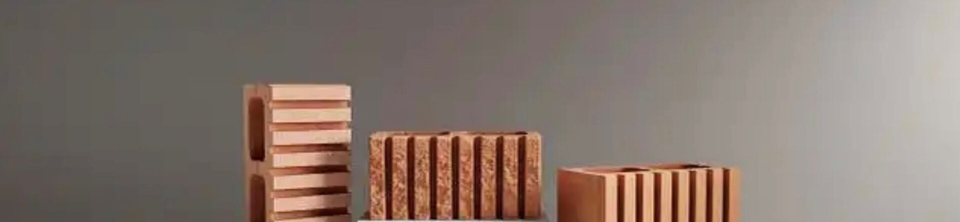 Blocchi in laterizio esposti su piedistalli bianchi in un ambiente neutro